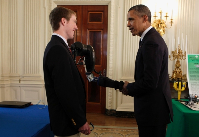 President Obama shakes hands with the robotic arm that Easton LaChappelle invented. (photo courtesy of www.america.aljazeera.com) 