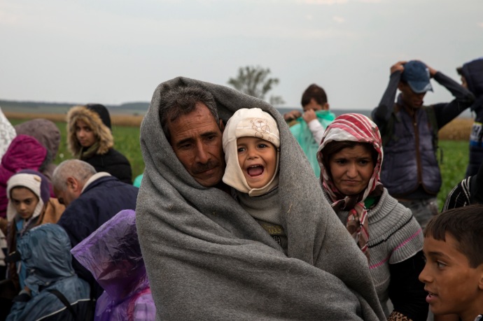 Migrants stand in a field as they wait for buses, after crossing the border from Serbia, near Tovarnik, Croatia September 24, 2015. Hungary may consider opening a "corridor" for migrants to pass through from Croatia by train or bus if Austria and Germany want one and take full responsibility, Prime Minister Viktor Orban's chief of staff said on Thursday. The route of migrants journeying northwards through the Balkans from Greece shifted to Croatia and Slovenia after Hungary sealed off its border with Serbia earlier this month.  REUTERS/Marko Djurica - RTX1SBFP